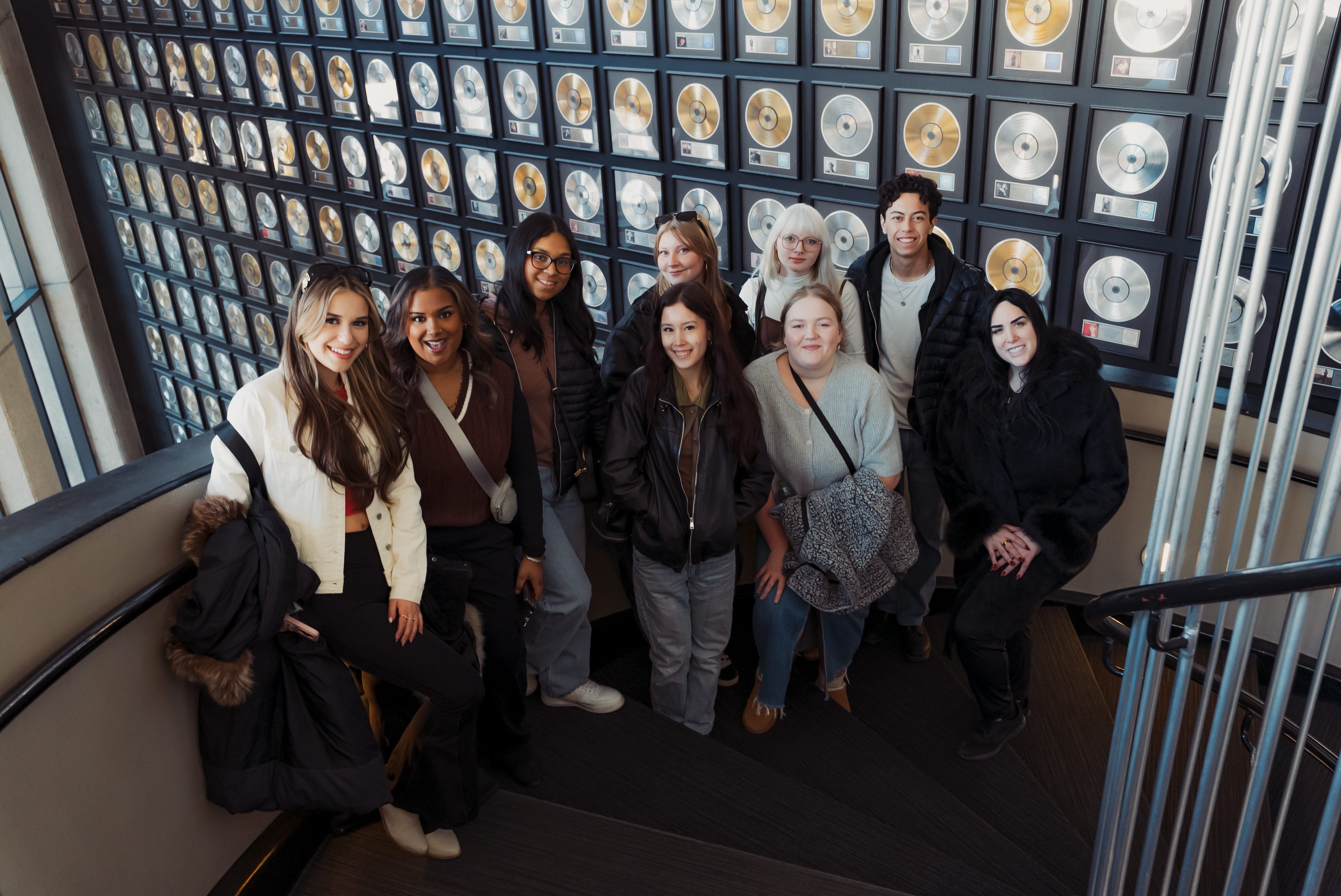 Group of students in front of records smiling.